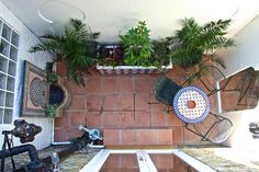 a kitchen with tiled floors and plants on the counter top, along with potted plants