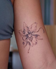 a woman's arm with a flower tattoo on the left side of her arm