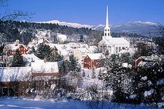 the town is covered in snow and surrounded by mountains