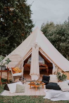 a large tent with chairs and tables in the grass