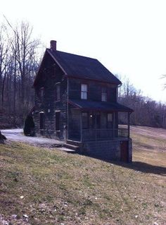 an old log house sitting on top of a hill