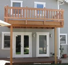 an outside view of a house with two doors and a deck