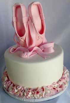 a cake decorated with pink ballet shoes and ruffles