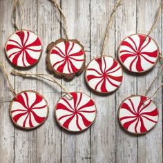 red and white peppermint ornaments hanging from string on wooden planked surface with wood background