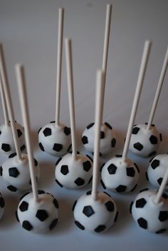 there are many black and white soccer balls on the table with toothpicks in them