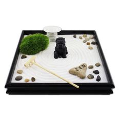 a small black dog sitting on top of a rock garden