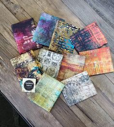 many different colored papers sitting on top of a wooden table