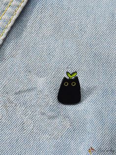 a small black object sitting on top of a blue jean jacket with yellow stitching