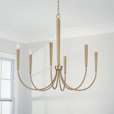 a chandelier hanging from a ceiling in a room with white walls and windows