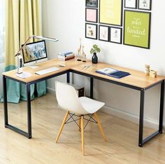 a corner desk with a computer on it in front of a window and pictures hanging on the wall