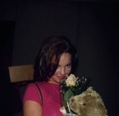 a woman holding a teddy bear in her arms