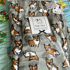 an image of a blanket with corgis on it and a tag attached to it