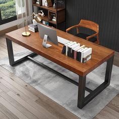 a computer desk with books and a laptop on it