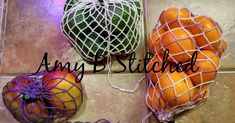 three oranges in mesh bags sitting on top of a tile floor next to each other