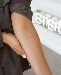 a woman's arm with a small tattoo on the left side of her leg