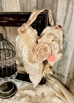 a heart shaped piece of fabric with flowers on it next to a birdcage