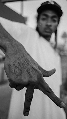 a black and white photo of a man with his hand in the shape of a peace sign