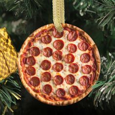 a pepperoni pizza ornament hanging from a christmas tree