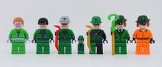 a group of legos that are all wearing green and orange outfits with hats on