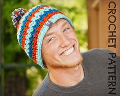 a smiling man wearing a multicolored knitted hat