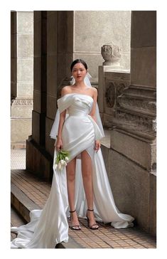 a woman in a white wedding dress posing for the camera