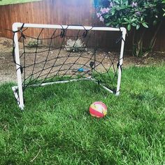 a soccer ball sitting in the grass next to a goal