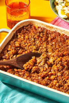 a casserole dish filled with baked beans and other food items on a table