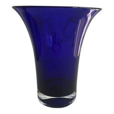 a blue glass vase sitting on top of a white table