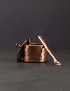 two copper pots with spoons in them