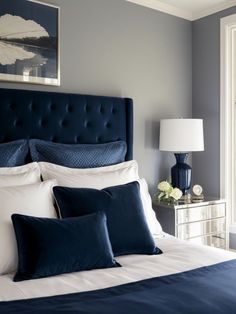 a bed with blue and white pillows in a bedroom