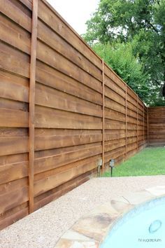 a wooden fence next to a swimming pool