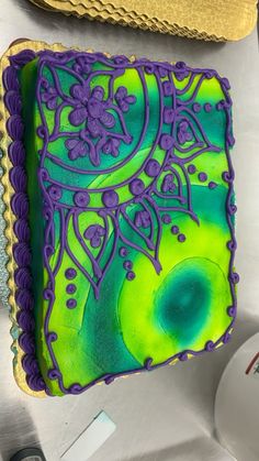 a green and purple cake sitting on top of a table