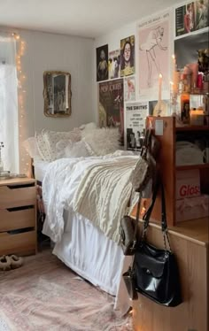 a bedroom with white bedding and lots of pictures on the wall