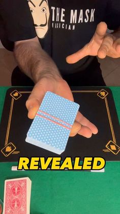 the man is holding up his hand to show how he has been revealed by playing cards