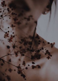 a woman's back with flowers in her neck and chest, against a white background