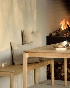 a wooden table sitting next to a fire place