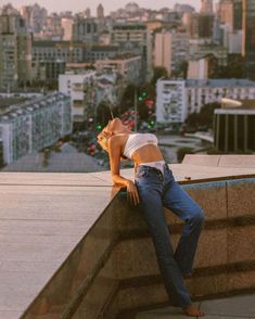 a woman leaning on the edge of a building