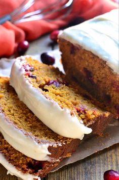 two slices of cake with white frosting and cranberries