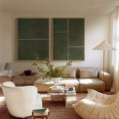 a living room filled with white furniture and green chalkboard wall art on the walls