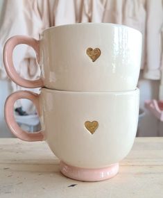 two white cups with gold hearts on them