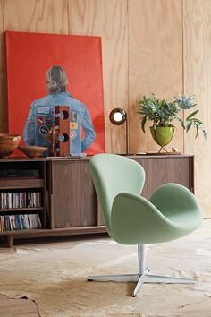 a green chair sitting in front of a book shelf