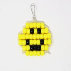 a yellow and black beaded ornament on a white background with clippings