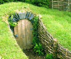 a wooden door in the middle of a grass covered field with vines growing around it