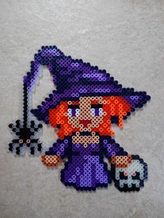 a pixellated image of a little witch holding a pumpkin and a spooky hat