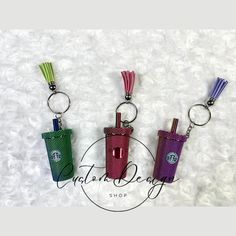 three key chains with starbucks coffee cups in them on a white furnishing background