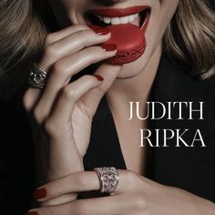 A woman biting a red macaroon while wearing jewelry from Judith Ripka. The Conjuring, Sweet Tooth