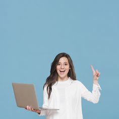 a woman holding a laptop and making the peace sign with her hand while standing in front of a blue background