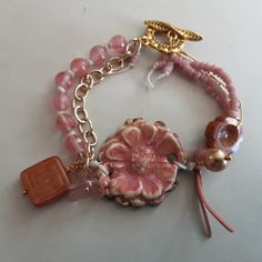 Handcrafted Ceramic Focal by SuzieQBeads in a pink flower with Cherry Quartz, African glass beads and gold chain and toggle Pink Jewelry With Adjustable Round Beads Chain, Pink Beaded Czech Glass Jewelry, Handmade Pink Czech Glass Jewelry, Handmade Pink Glass Jewelry, Pink Bohemian Beaded Bracelets In Czech Glass, Bohemian Pink Beaded Bracelets From Czech Glass, Bohemian Pink Beaded Bracelets Czech Glass, Pink Czech Glass Bracelet, Pink Glass Jewelry With Colorful Beads