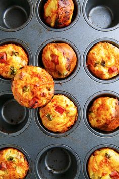 several muffins with different toppings sitting in a muffin tin