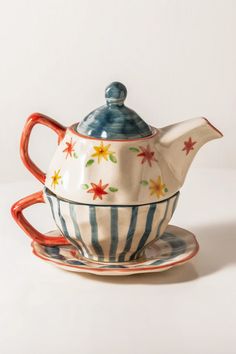 a tea pot and saucer sitting on top of each other